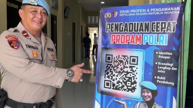 Petugas Sie Propam menunjukkan banner "Pengaduan Cepat Propam Polri" yang memuat kode QR layanan pengaduan masyarakat, di Polres Malinau.