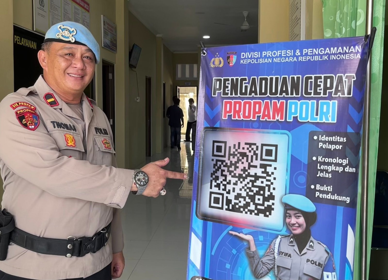 Petugas Sie Propam menunjukkan banner "Pengaduan Cepat Propam Polri" yang memuat kode QR layanan pengaduan masyarakat, di Polres Malinau.