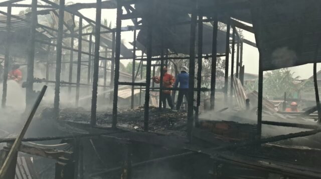 Petugas Damkar Malinau menyemprotkan air ke arah sisa-sisa bangunan rumah yang terbakar di Gang Baya Taka, RT 15, Desa Malinau Kota, Rabu (7/10/2026).